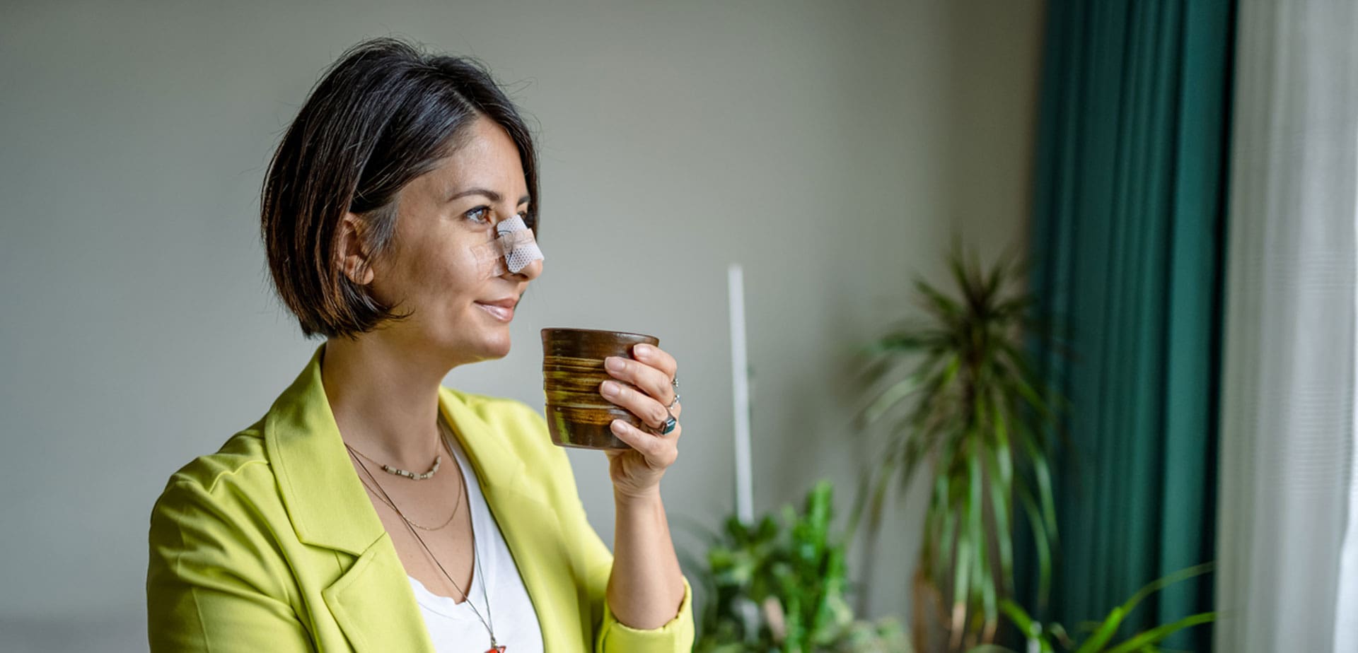 woman-standing-by-a-window-holding-a-mug
