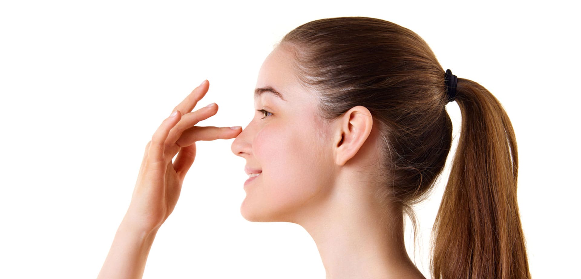 woman-touching-the-bridge-of-her-nose-against-a-white-background